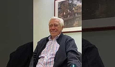 Smiling man seated in an office setting.